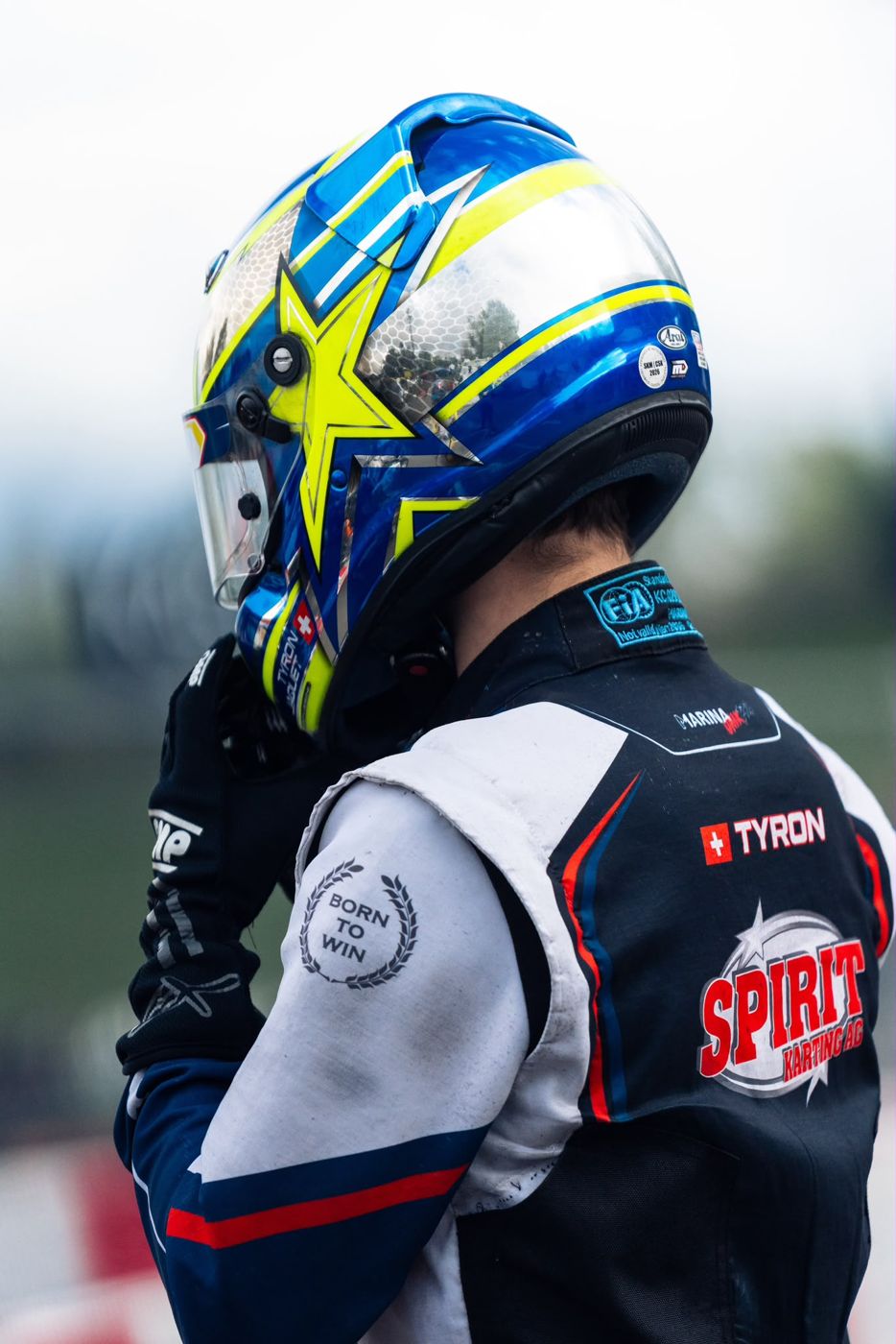 Tyron Jaquet de dos, casque bleu et jaune, combinaison Spirit Karting
